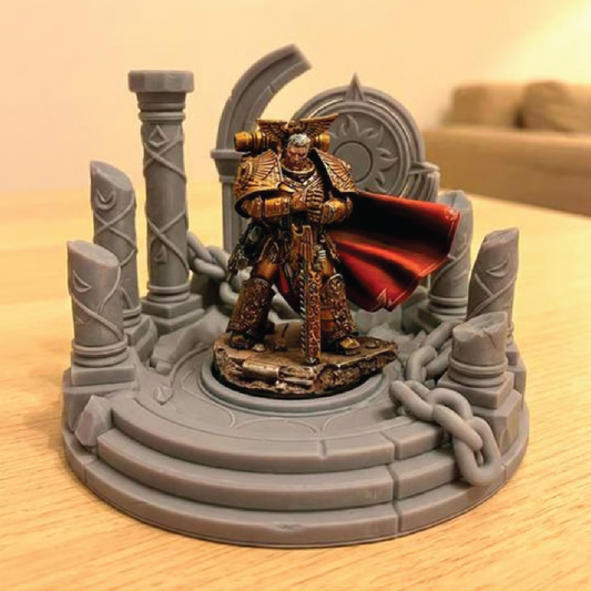 Figurine of a warrior in ornate armor with a red cape on a detailed gray platform.