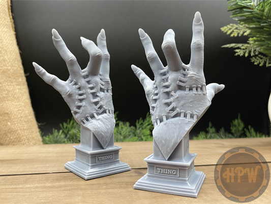 A pair of busts of Thing 3D printed in gray resin.