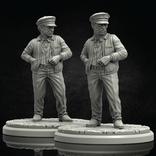 Two unpainted gray miniature figurines of elderly men in military-style uniforms standing on round bases against a dark studio background.