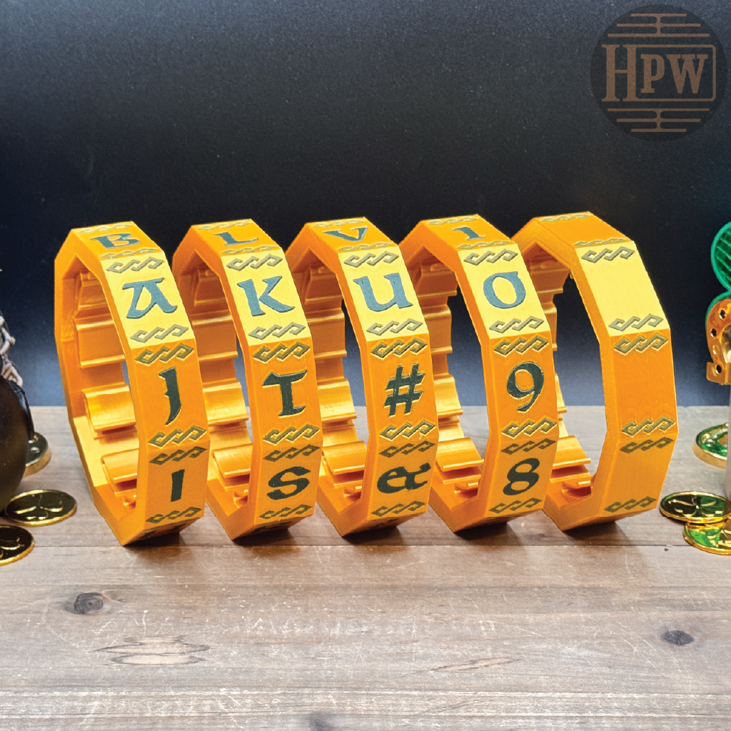 Set of yellow metal letter and number bracelets on a wooden surface with a dark background.