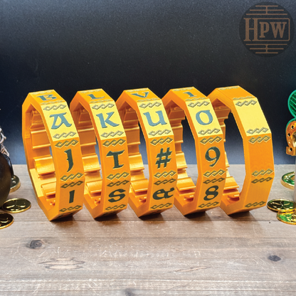 Set of yellow metal letter and number bracelets on a wooden surface with a dark background.