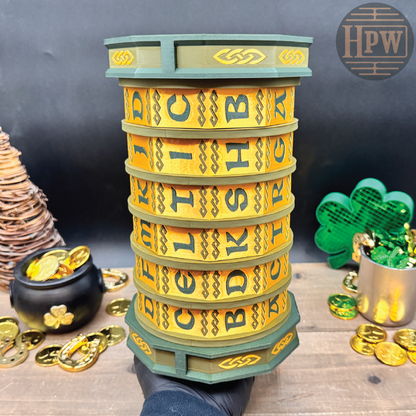 Stack of yellow letter tiles with green base on a wooden surface, surrounded by gold coins and a pot of gold.