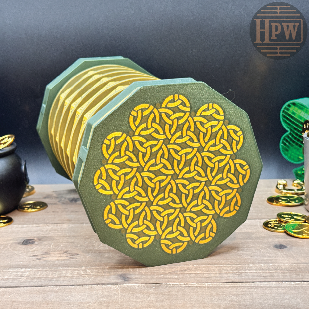 Hexagonal coaster with yellow pattern on a wooden surface, surrounded by decorative items.
