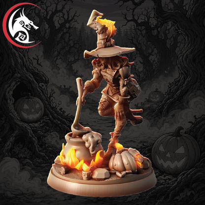 A fantasy miniature figurine of a witch in armor and a pointed hat, holding a cauldron with flames, standing on a base with pumpkins and a cauldron. The background is a dark, spooky forest scene with jack-o'-lanterns.