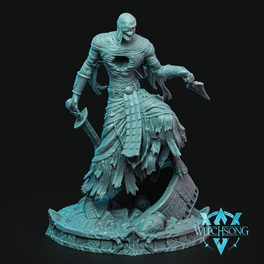 A fantasy miniature figurine of a skeletal warrior in tattered armor and skirt, holding a sword and dagger, standing on a detailed circular base. The figurine is painted in a pale icy blue color and is photographed against a solid black background.