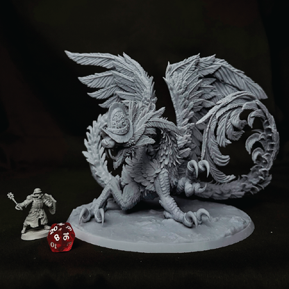 An unpainted gray fantasy creature miniature figurine posed on a round base next to a small gray human character and a red translucent die, against a dark background.
