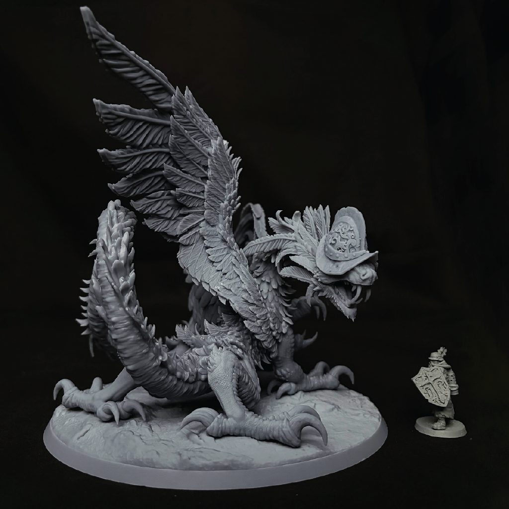 An unpainted gray fantasy dragon miniature figurine on a round display base, shown against a black background with a small shielded companion figure beside it.