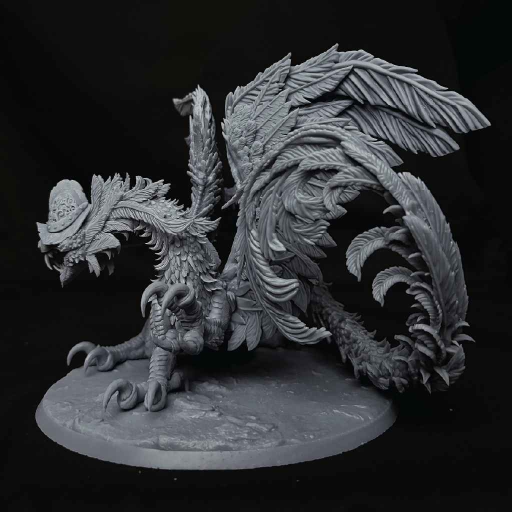 An unpainted gray fantasy creature miniature figurine with large feathered wings and a detailed textured body, standing on a round base against a black background.