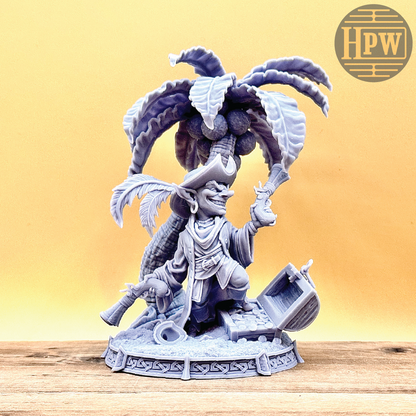 A goblin pirate wielding miniature blunderbusses standing under a palm tree and on top of an open treasure chest full of coins. This is a model 3D printed in gray UV resin.