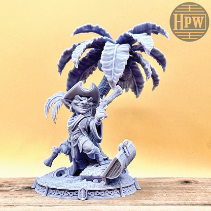 A goblin pirate wielding miniature blunderbusses standing under a palm tree and on top of an open treasure chest full of coins. This is a model 3D printed in gray UV resin.