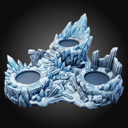 An icy fantasy tabletop terrain piece featuring three circular pits surrounded by jagged blue ice spires, rocky ruins, and snow-like textures on a dark gradient background.
