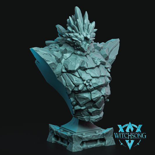 A fantasy bust sculpture of a rocky, crystalline creature's head on a pedestal, rendered in a light icy blue color against a solid black background. The Witchsong logo is visible in the bottom right corner.