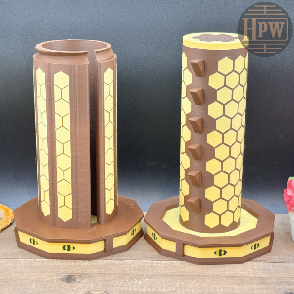 Two cylindrical honeycomb-shaped objects on a wooden surface with a dark blue background.