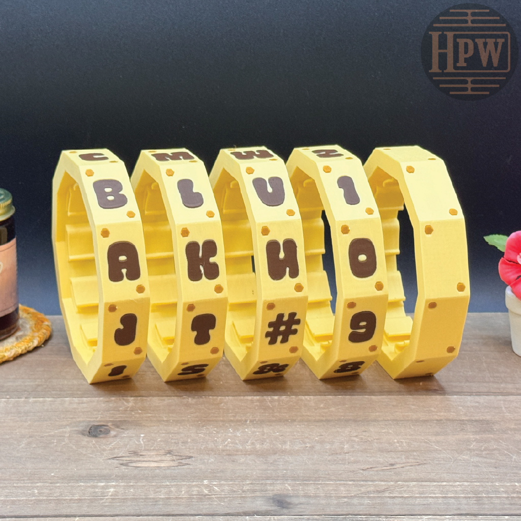 Yellow bracelet with letters and symbols on a wooden surface with a dark background
