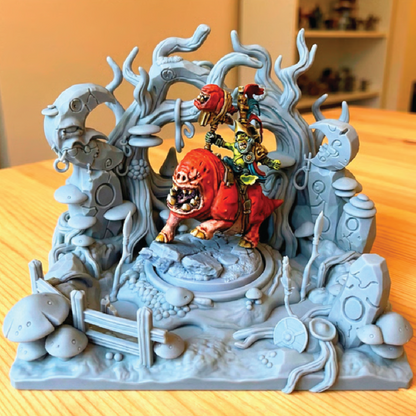 Decorative figurine with a red lion-like creature and smaller figures on a gray base.
