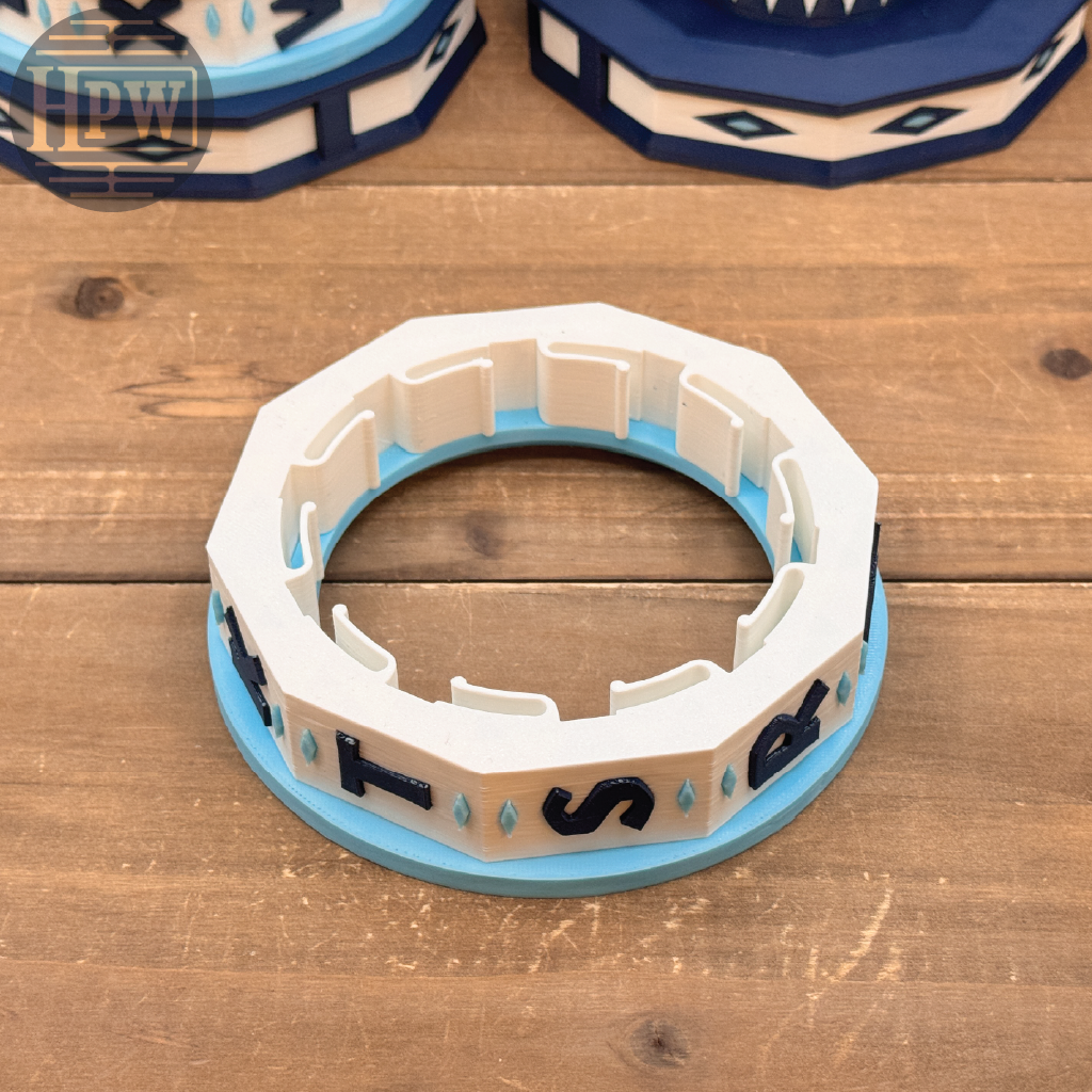 Decorative ring with blue and white design on a wooden surface