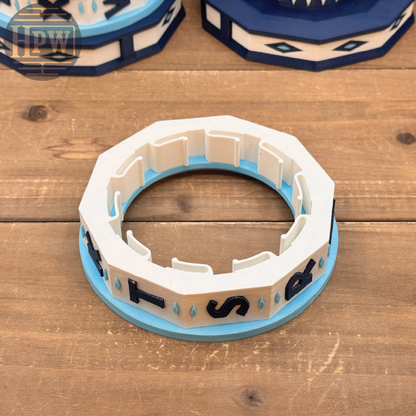 Decorative ring with blue and white design on a wooden surface