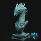 A detailed fantasy bust sculpture of a dragon head on a pedestal base, shown in a light teal-blue color against a solid black background. A 'WITCHSONG' brand logo is visible in the bottom right corner.