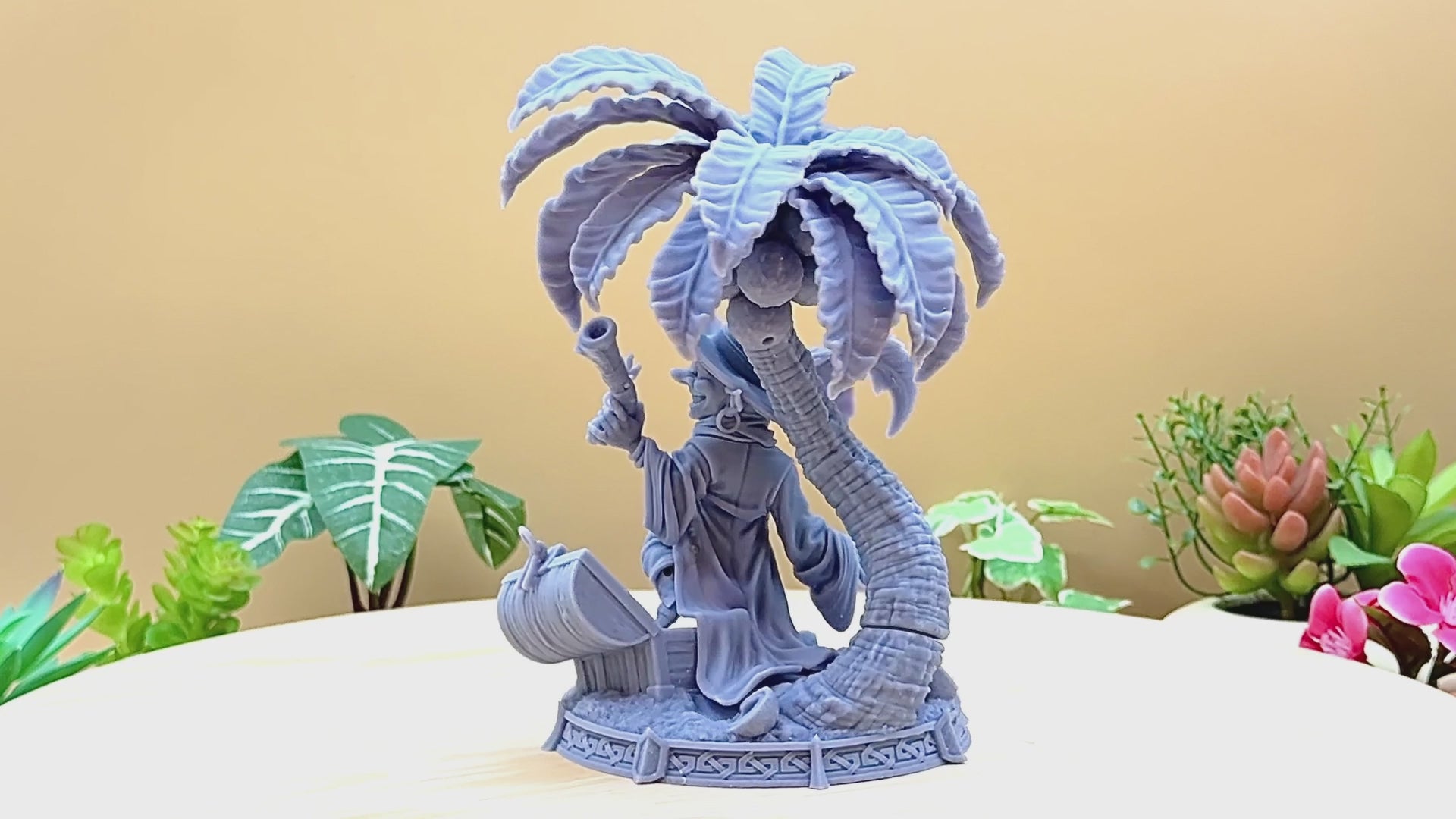 A goblin pirate wielding miniature blunderbusses standing under a palm tree and on top of an open treasure chest full of coins. This is a model 3D printed in gray UV resin.
