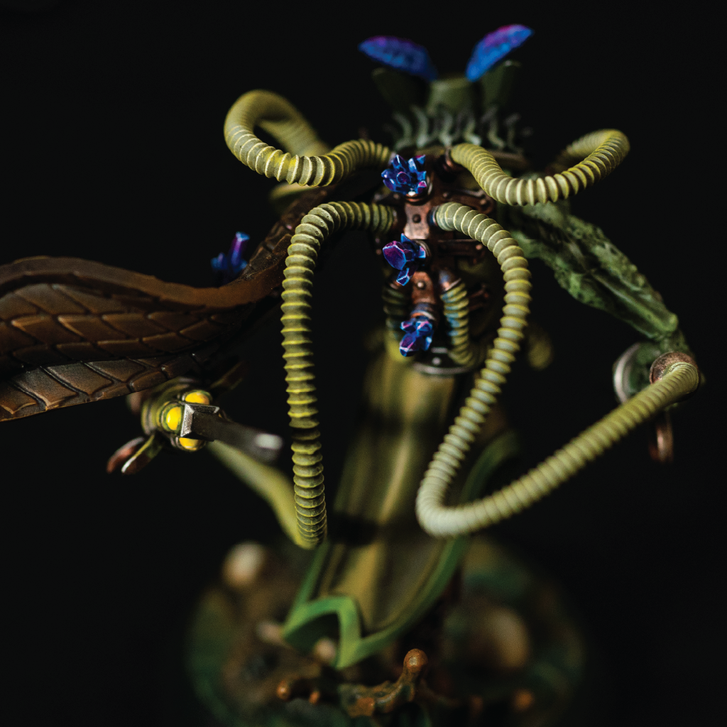 Close-up of a detailed dragon-like creature with serpentine appendages on a dark background