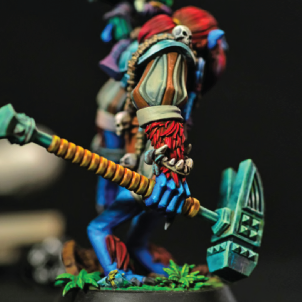 Colorful painted miniature figure with a weapon on a dark background