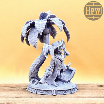 A goblin pirate wielding miniature blunderbusses standing under a palm tree and on top of an open treasure chest full of coins. This is a model 3D printed in gray UV resin.