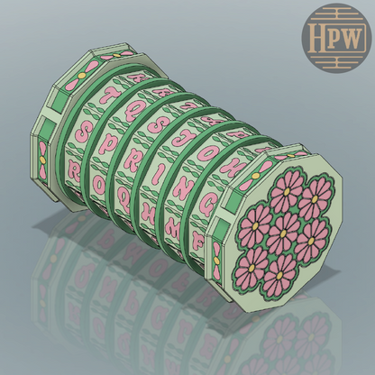 Decorative letter and flower roll with HPW logo on a reflective surface