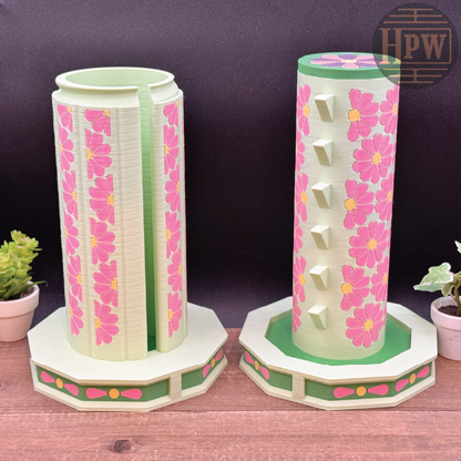 Two floral-patterned candle holders on a wooden surface with a dark background