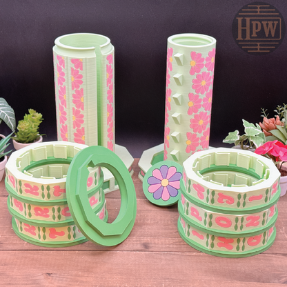 Set of floral-patterned plastic containers on a wooden surface with plants in the background.