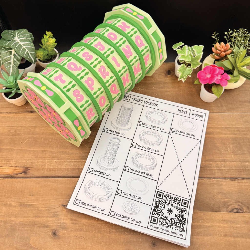 Roll of green and pink patterned tape with a spring lockbox kit on a wooden surface.