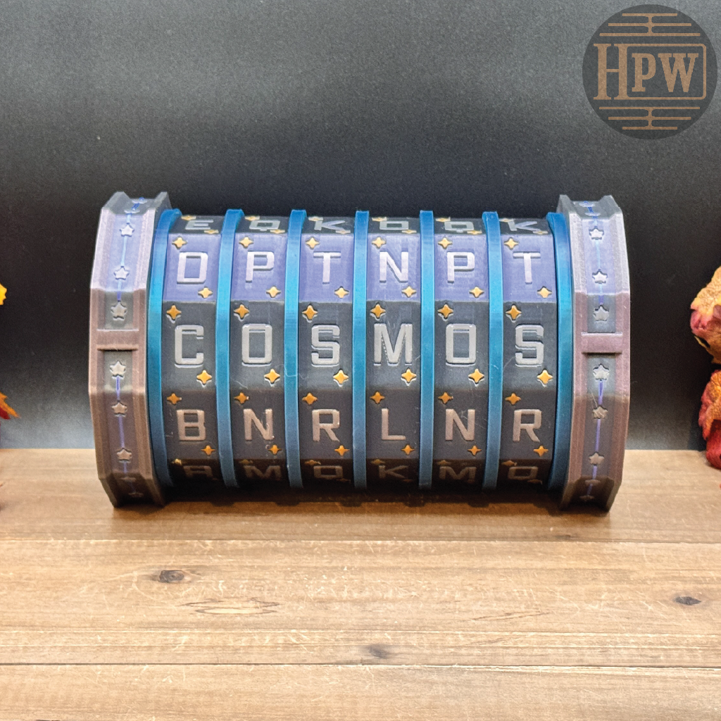 A cylindrical, multi-letter rotating lock or combination device with blue and gray segments, resting on a wooden surface against a dark background.