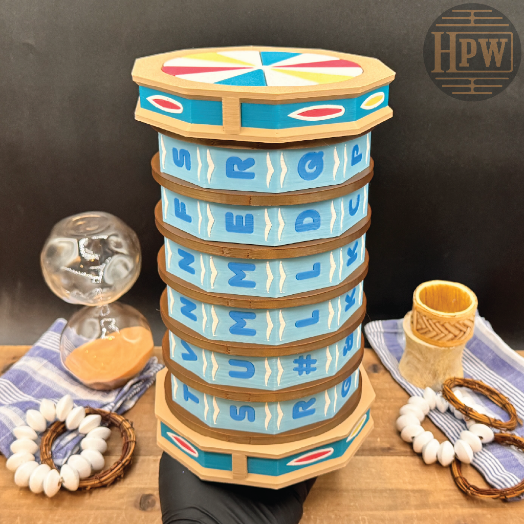 A handcrafted wooden drum stack with painted blue, turquoise, and natural wood bands, displayed on a wooden surface with decorative props including a glass hourglass, woven bracelets, and a small basket cup against a dark backdrop.