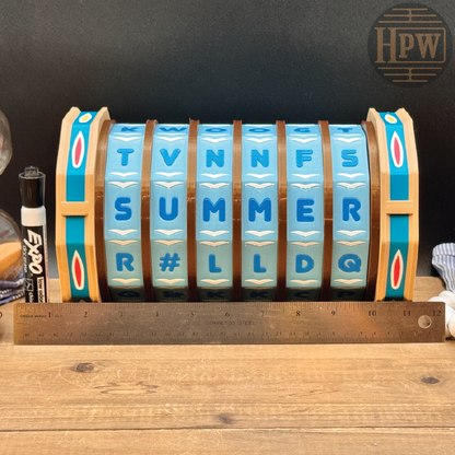A vintage-style summer temperature dial clock with blue lettered dials, brown wooden bands, and turquoise side panels, shown on a wooden tabletop with a metal ruler underneath for scale. An HPW logo watermark is visible in the top right corner.