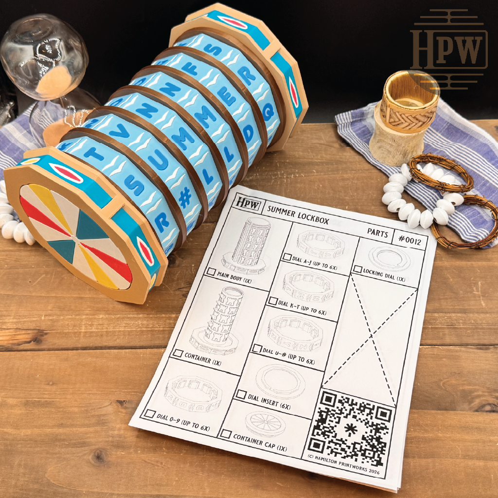 A wooden summer lockbox, displayed on a wooden table next to a printed parts manual. The lockbox features alternating blue and brown bands with white retro lettering, and a colorful circular end cap.